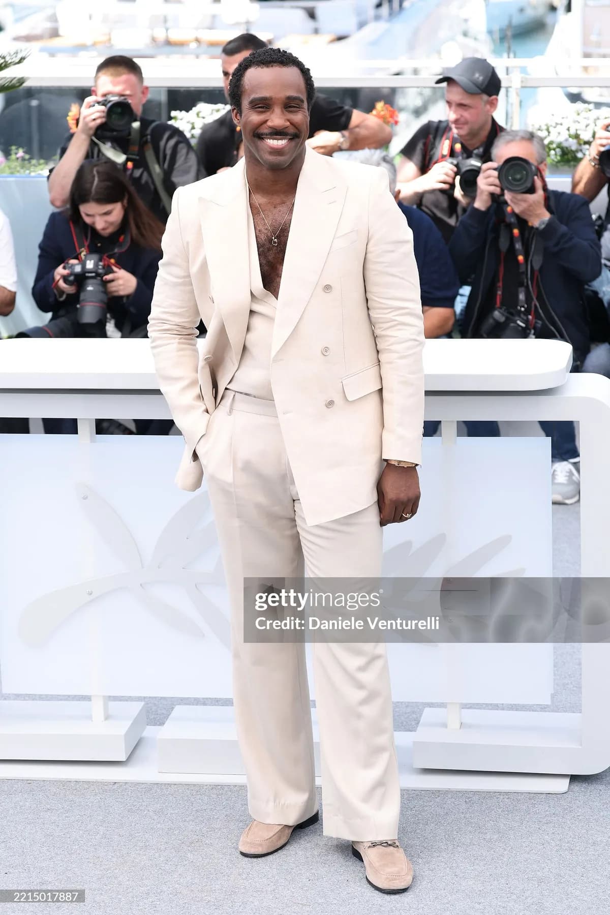 Ivory suit and waistcoat with tonal loafers, photographed at a Cannes photocall.