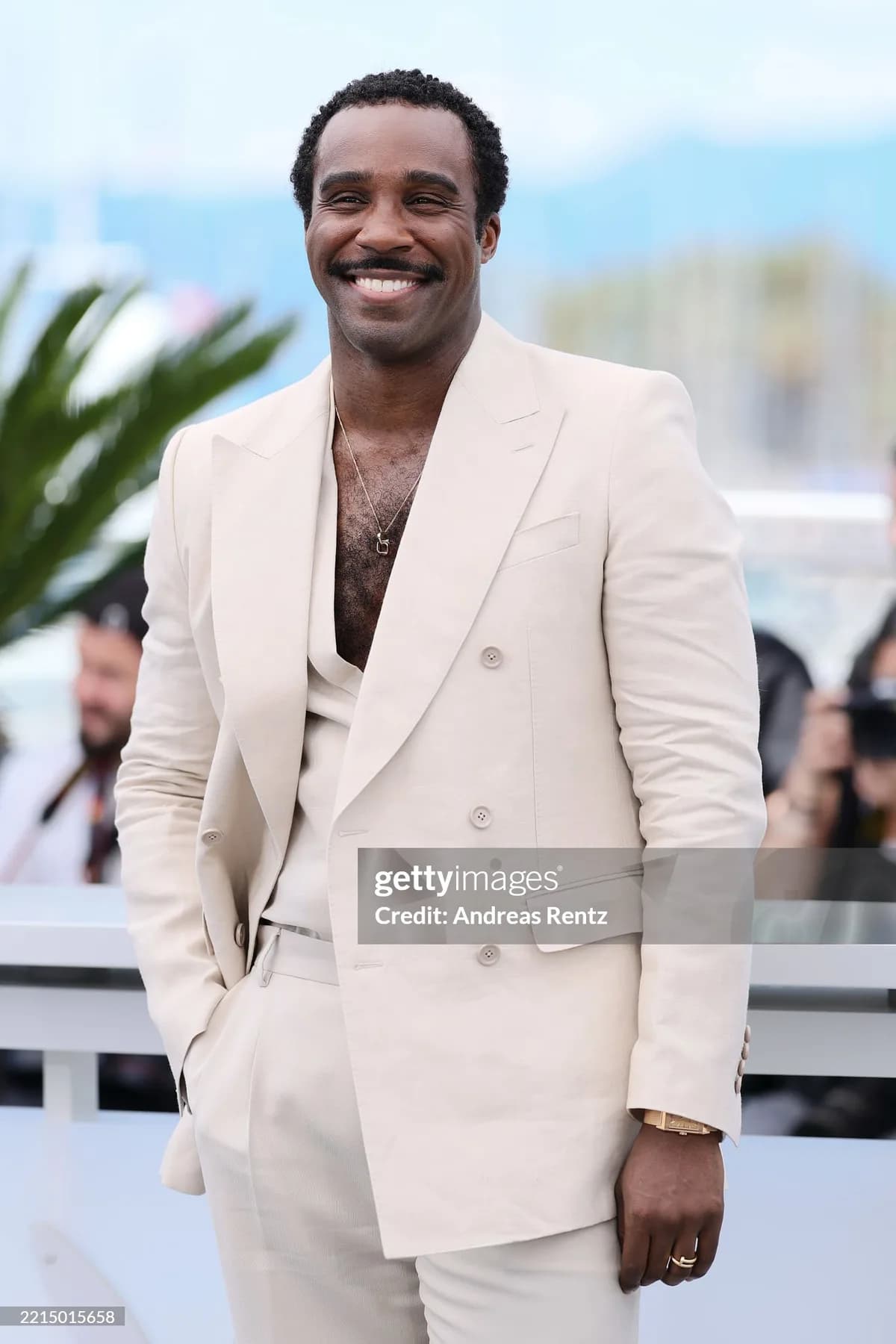 Ivory three piece suit with a matching waistcoat and softly rolled lapels, worn at a daytime photocall.