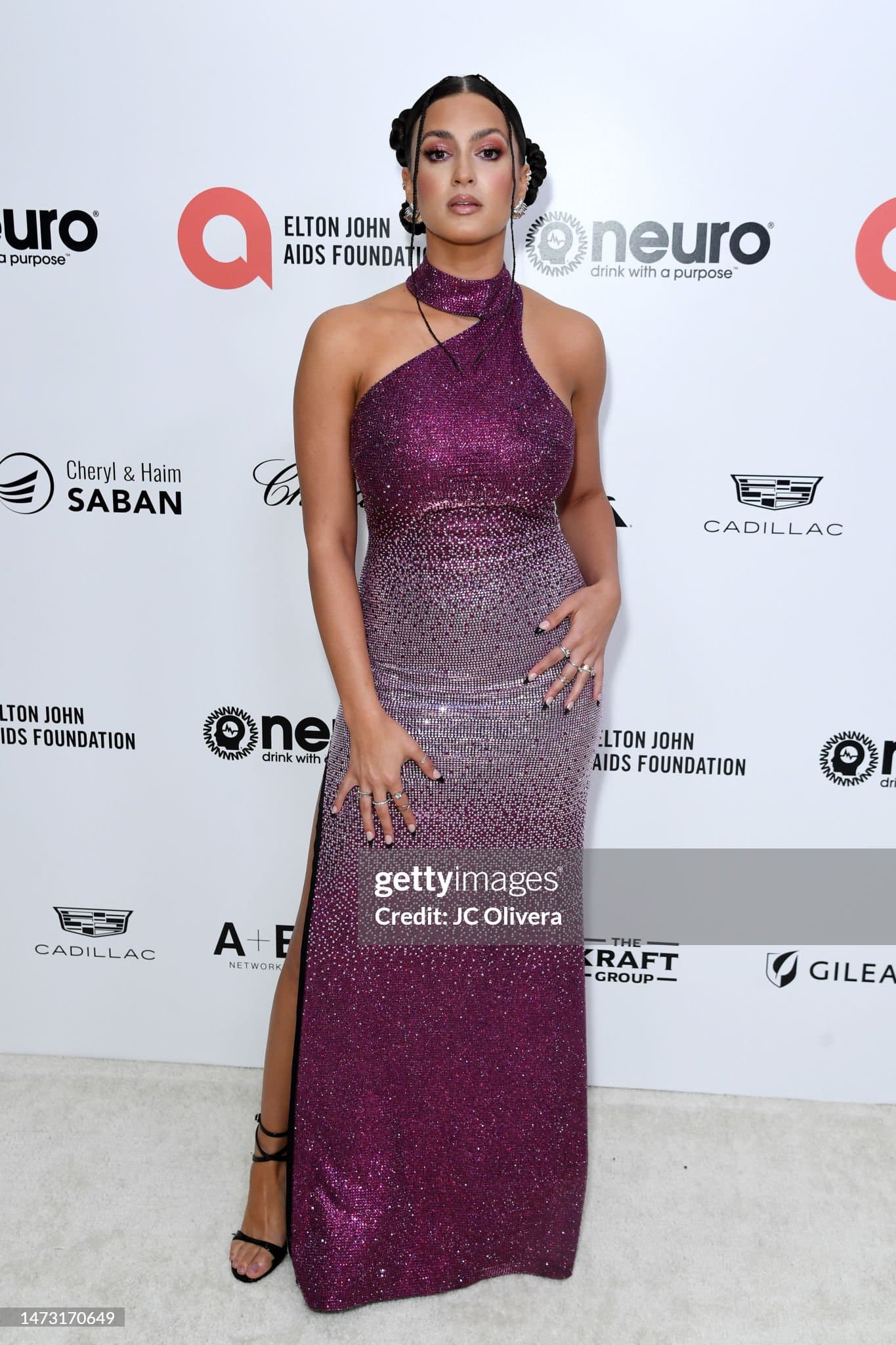 Crystal covered magenta halter gown with an asymmetric neckline and a thigh slit.